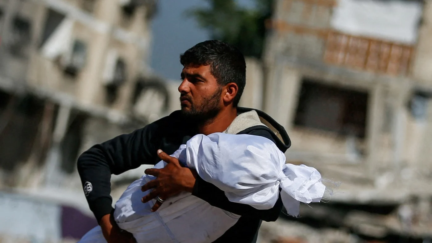 gaza-man-carries-palestinian-child-killed-by-israel-reuters-16-may-2025.jpg