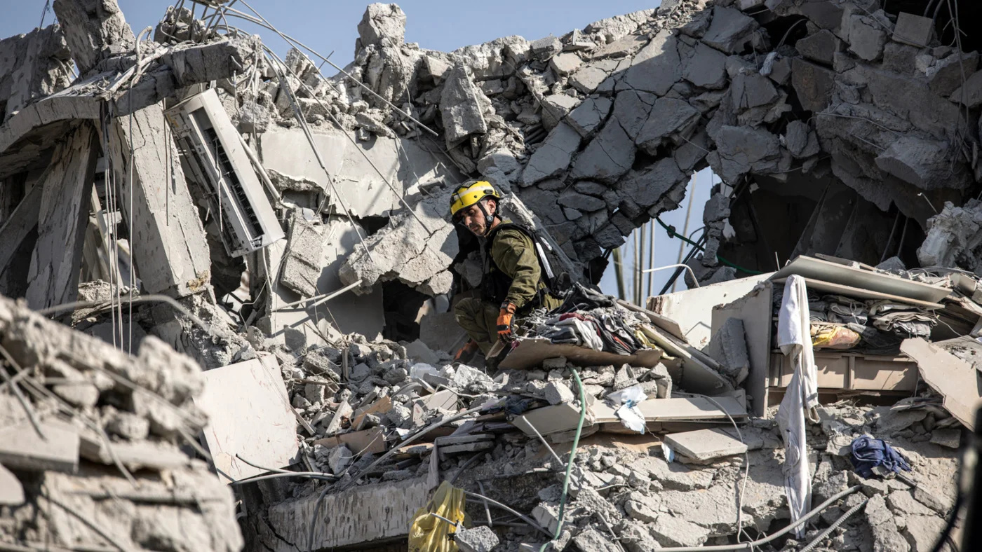 Israeli emergency responders inspect a site hit by a missile fired from Iran south of Tel Aviv on June 14, 2025 (AFP).jpg