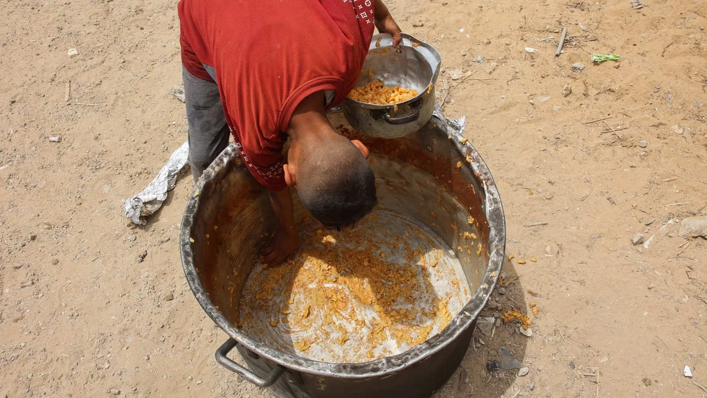 gaza-child-scrapes-food-pot-food-kitchen-12-may-2025-afp.jpg