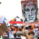 A protester holds a placard picturing Israel's Prime Minister Benjamin Netanyahu and reading 22 during a Pro-Palestinian march in central London, on March 15, 2025,-afp.jpg