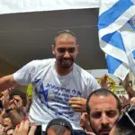 Izraeli elnök kegyelmet adott egy katonának, akit sebesült palesztin meggyilkolásáért ítéltek el. Israeli soldier Elor Azaria is lifted by friends near his family home in Ramla, near Tel Aviv, as they celebrate his release from prison, 8 May 2018 (AFP).jpg